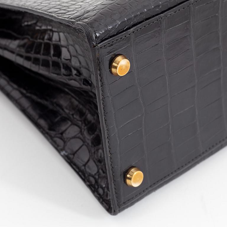 1962 black alligator 'Kelly' handbag by Hermès.