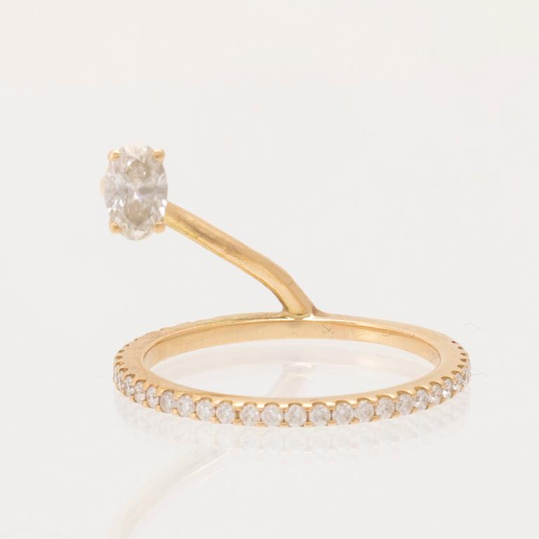 An 18K gold ring set with an oval cut and round brilliant cut diamonds by LWL Jewelry.