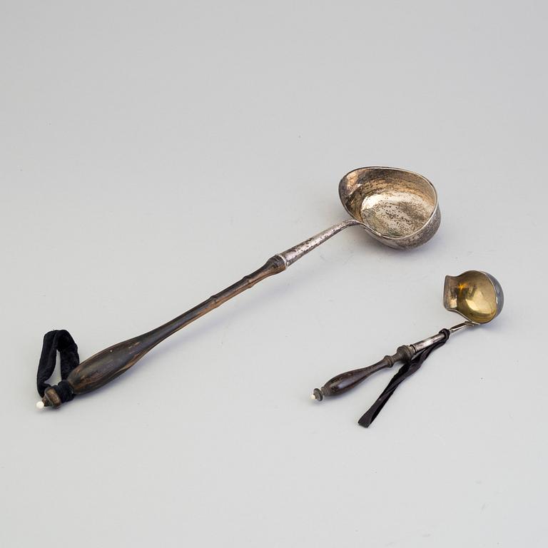 A 19th century silver soup and a sauce ladle with wooden handles.