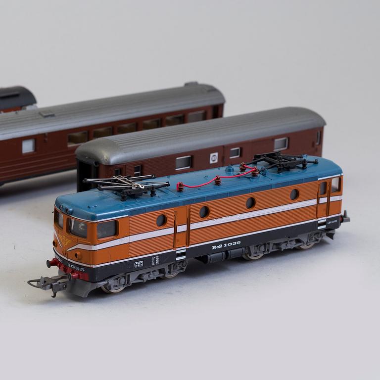 A set of Märklin electric trains, wagons,  rails, and a bridge.