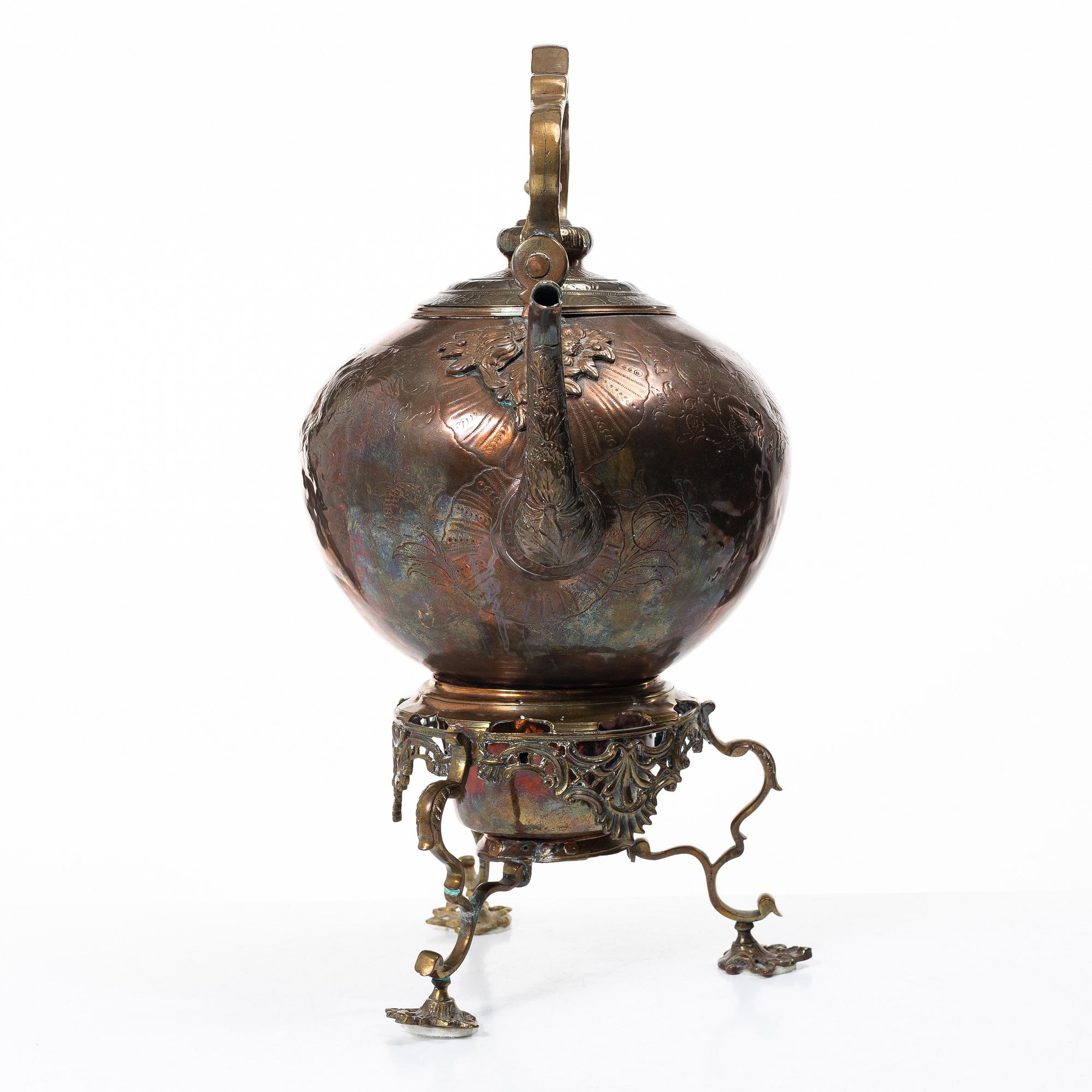 A German Rococo repoussé copper teapot on rechaud, mid 18th century.