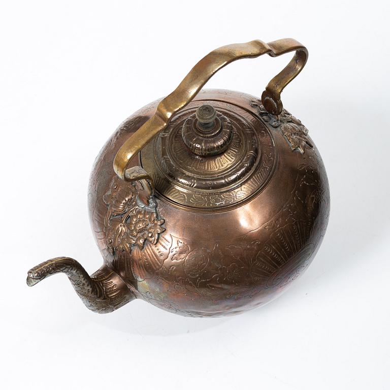 A German Rococo repoussé copper teapot on rechaud, mid 18th century.