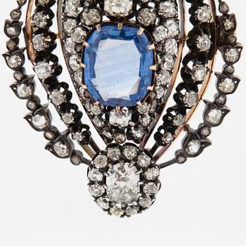 A silver and 14K gold brooch/pendant set with a faceted sapphire and old-cut diamonds.