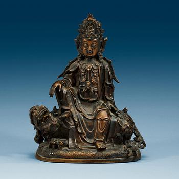 A bronze figure of Guanyin seated on a mythical beast, presumably Qing dynasty.