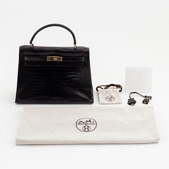 1962 black alligator 'Kelly' handbag by Hermès.