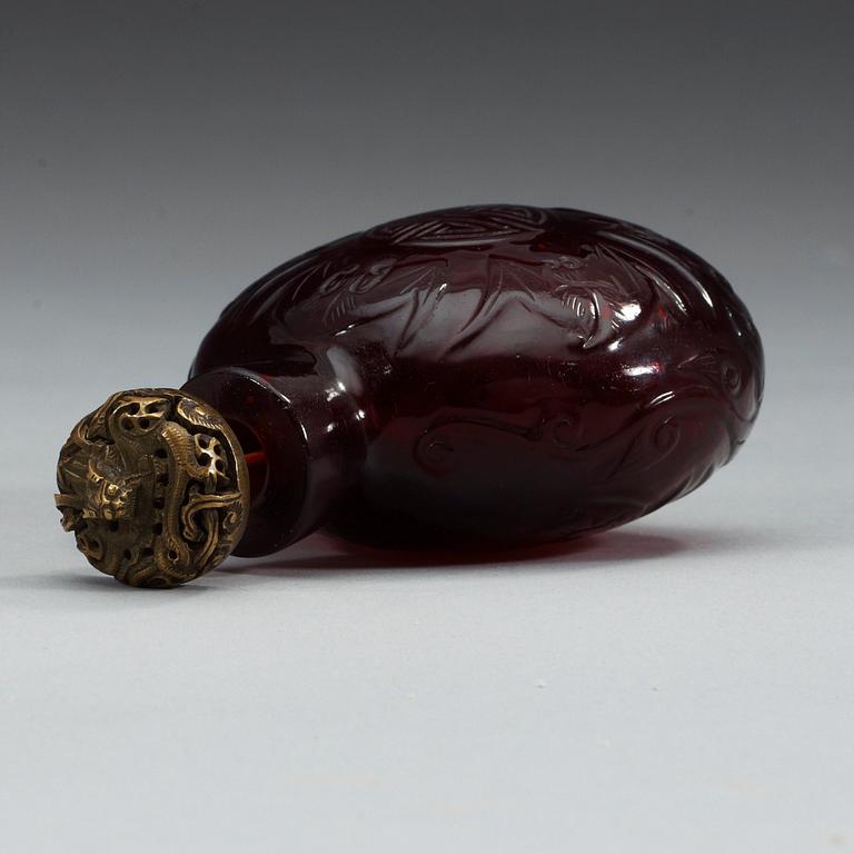A large red sculptured peking glass snuff bottle with stopper, presumably around 1900.
