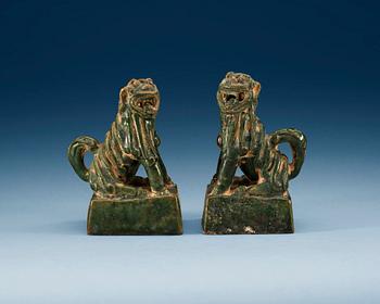 A pair of green glazed figures of 'Buddhist Lions', Ming dynasty.