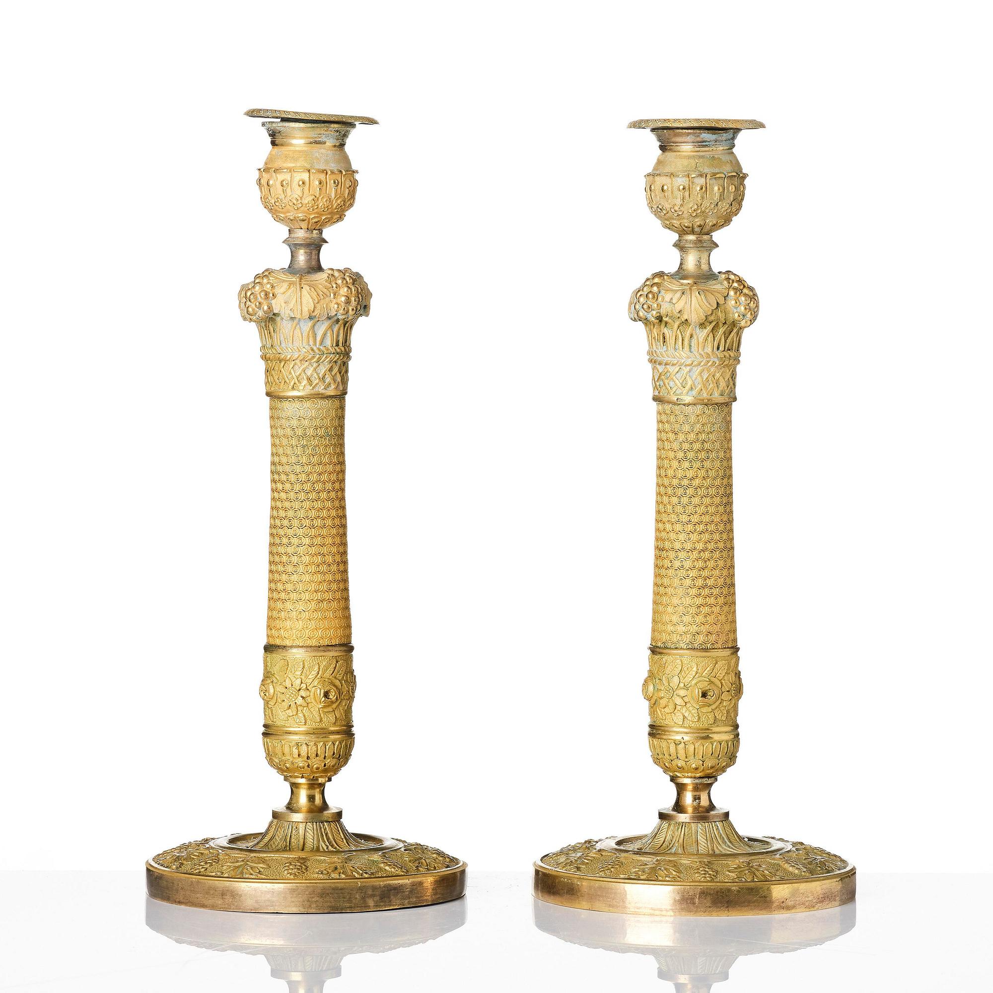 A pair of French Empire ormolu candlesticks, ca 1820's.