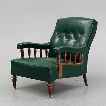 An early 20th Century easy chair with leather upholstery.