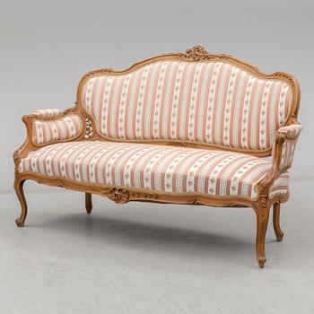 An end of the 19th Century rococo style walnut sofa with four chairs, two armchairs and a table.