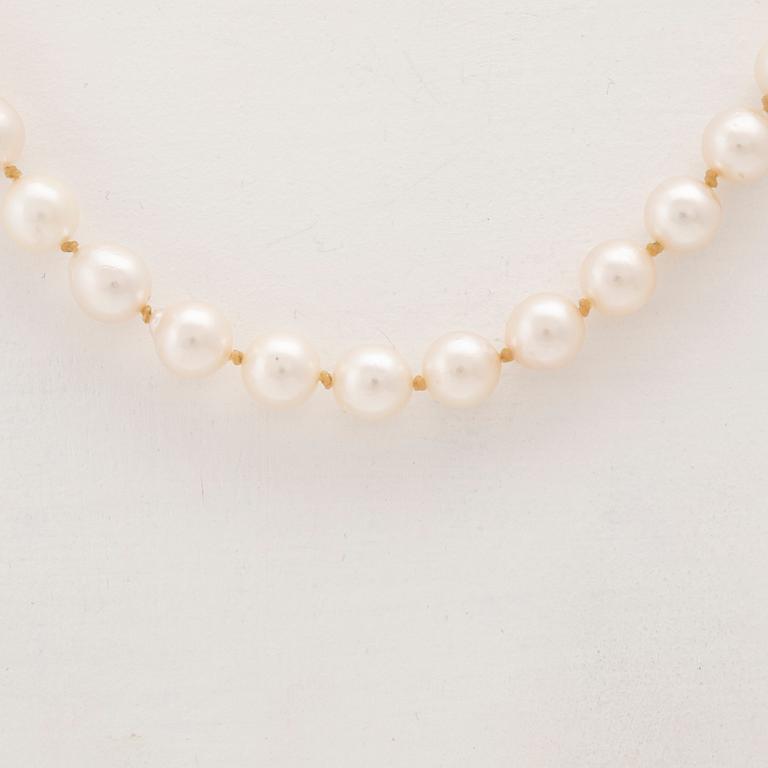 A necklace of cultured pearls with an 18K white gold lock set with single cut diamonds.