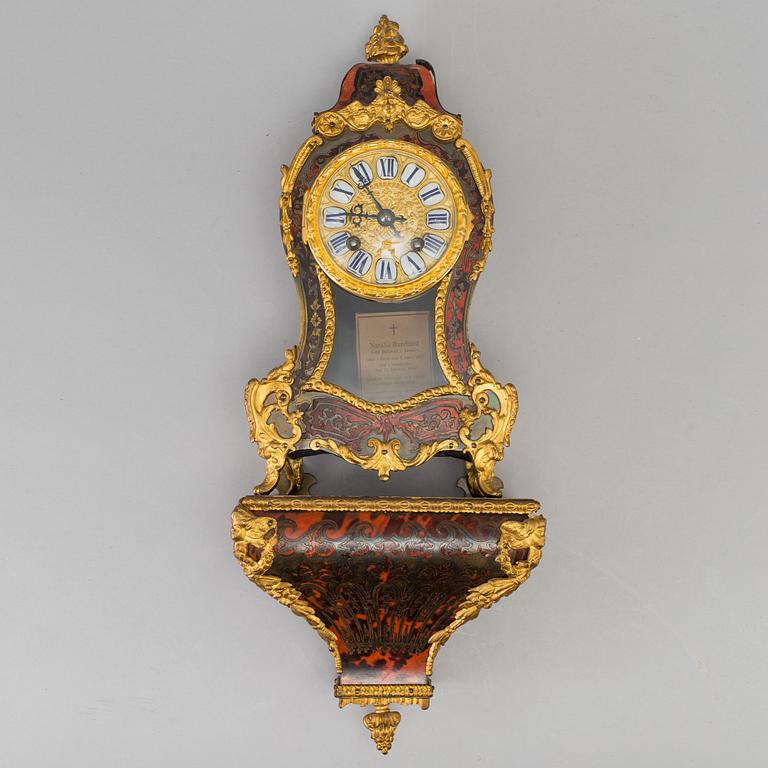 A Louis XV-style mantle clock with console base.