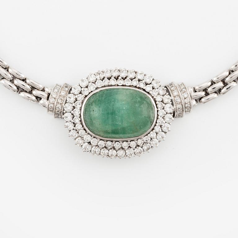 An 18K white gold necklace with a cabochon-cut emerald and round brilliant-cut diamonds.