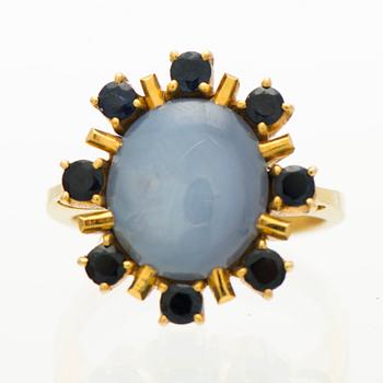 A RING, cabochon cut star sapphire, facetted sapphires, 18K gold.