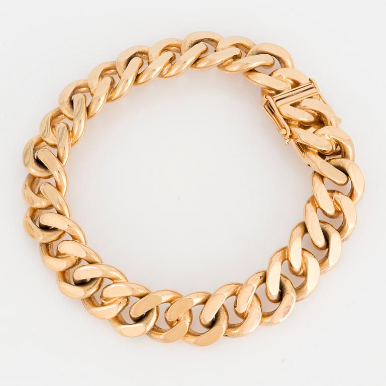 An 18K gold curb link bracelet.