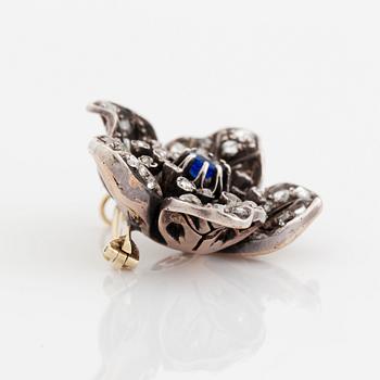 A silver and 14K gold brooch set with a blue stone and rose-cut diamonds.