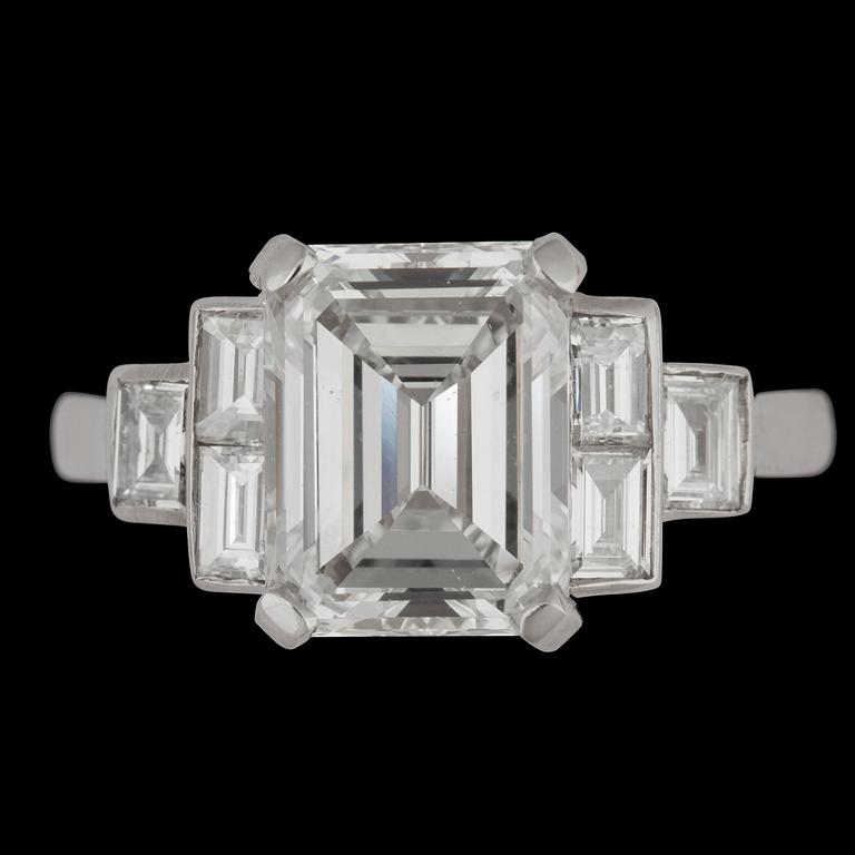 An emeralc cut diamond ring, 3.11 cts and small baguette cut diamonds, tot. app. 0.50 cts.