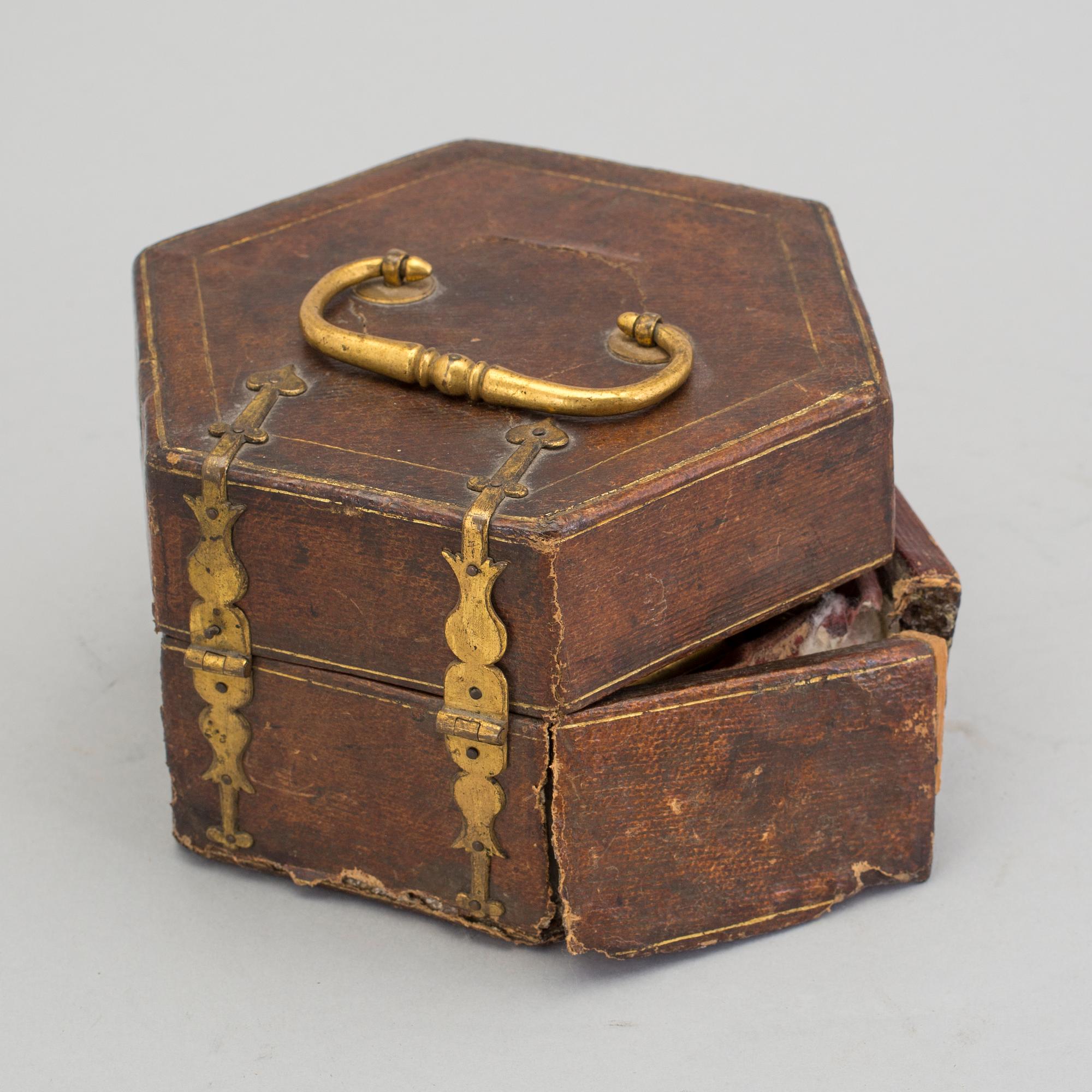 A gilded brass baroque travel clock from around 1700, with original case.