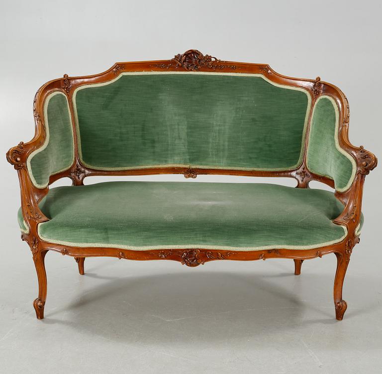 A rococo style sofa, two lounge chairs and a table, around the year 1900 and first half of the 20th century.