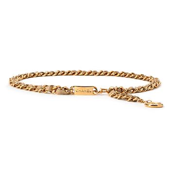 492. CHANEL, a beige leather and gold colored chain belt.