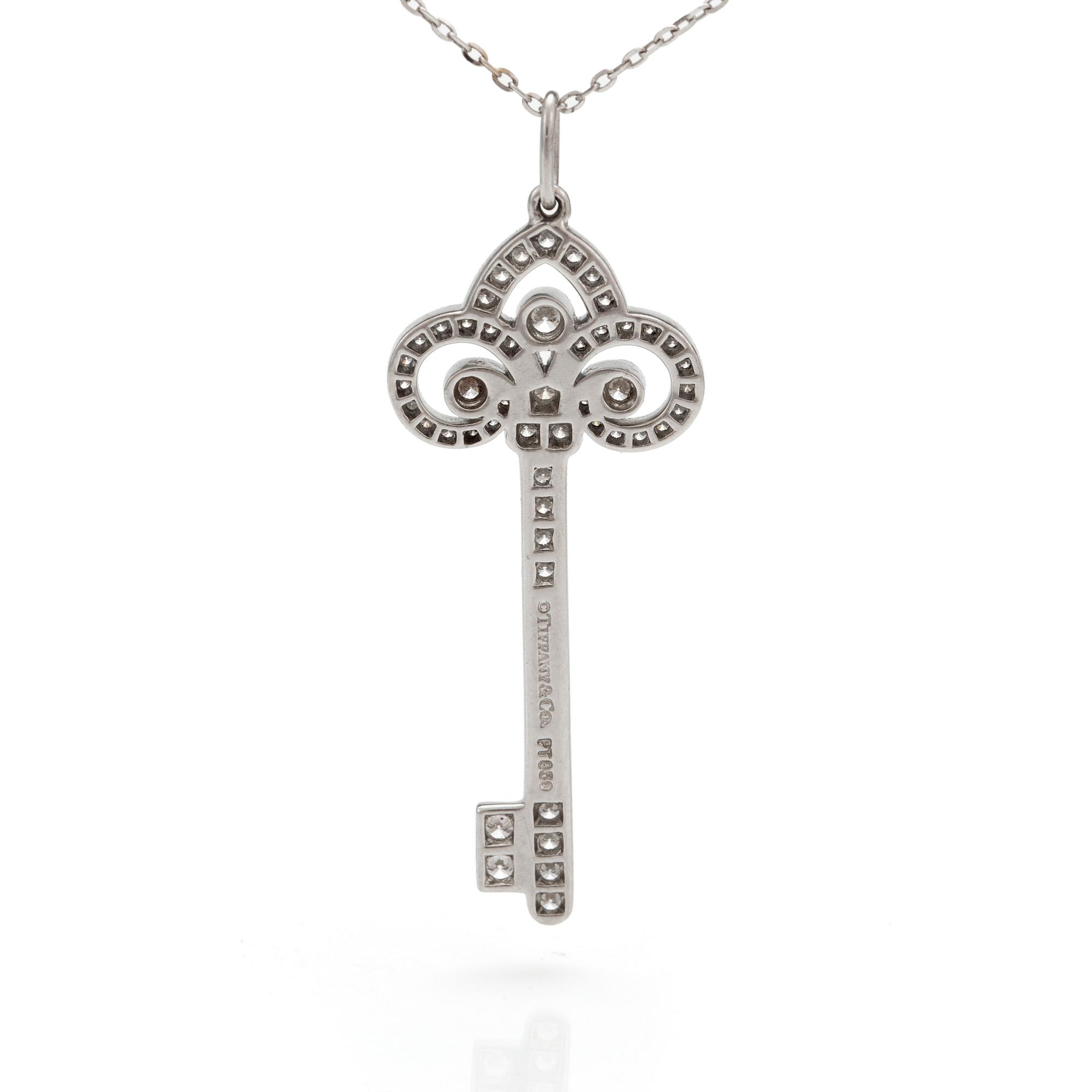 A 'Fleur de lis key' pendant set with round, brilliant-cut diamonds by Tiffany together with a chain.