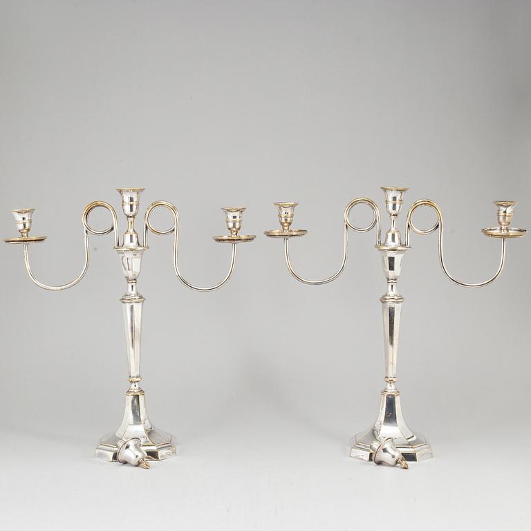 A pair of early 19th century silvered brass candelabra for three candles.