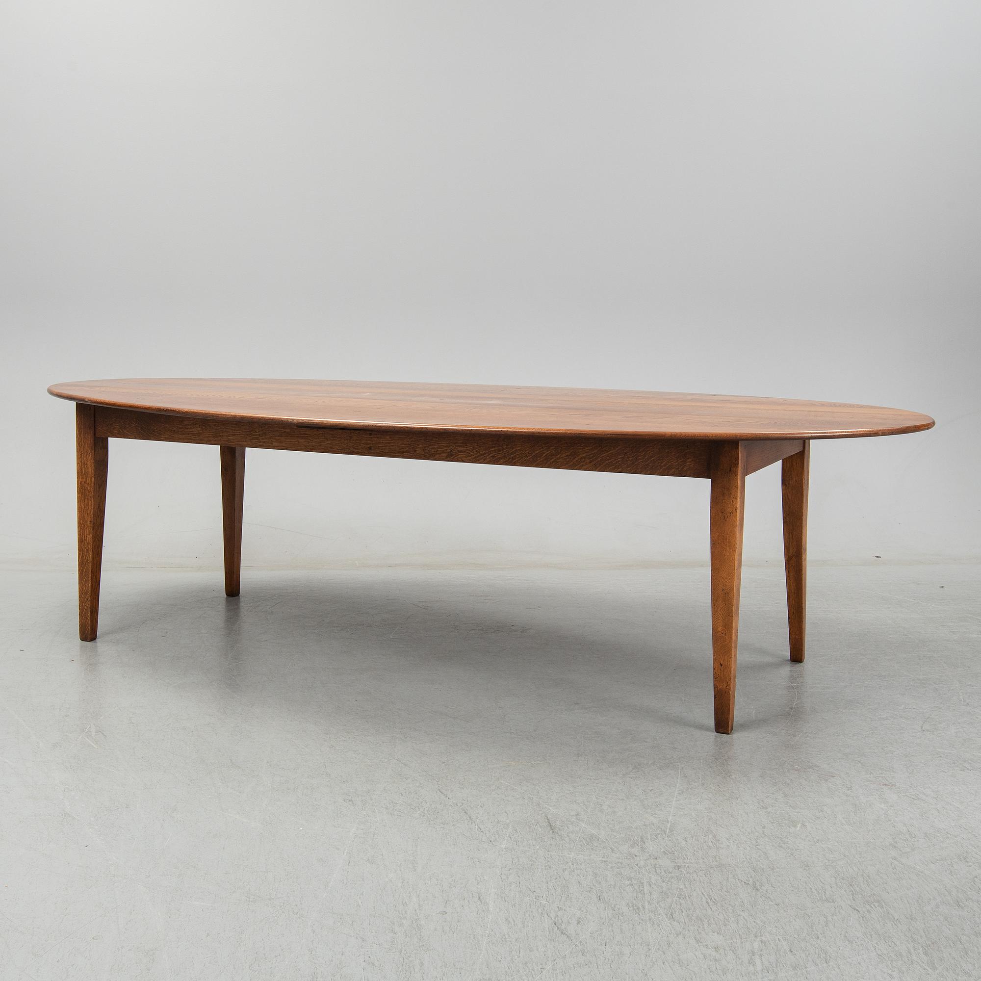 An stained oak dining table with eight chairs.