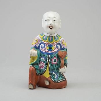 A porcelain figure of a laughing boy, Qing dynasty, 19th Century.