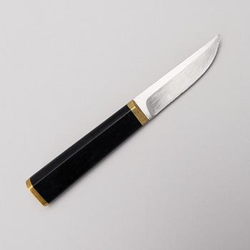 A Finnish puukko knife in stainless steel, nylon and brass designed by Tapio Wirkkala, Hackman Finland.