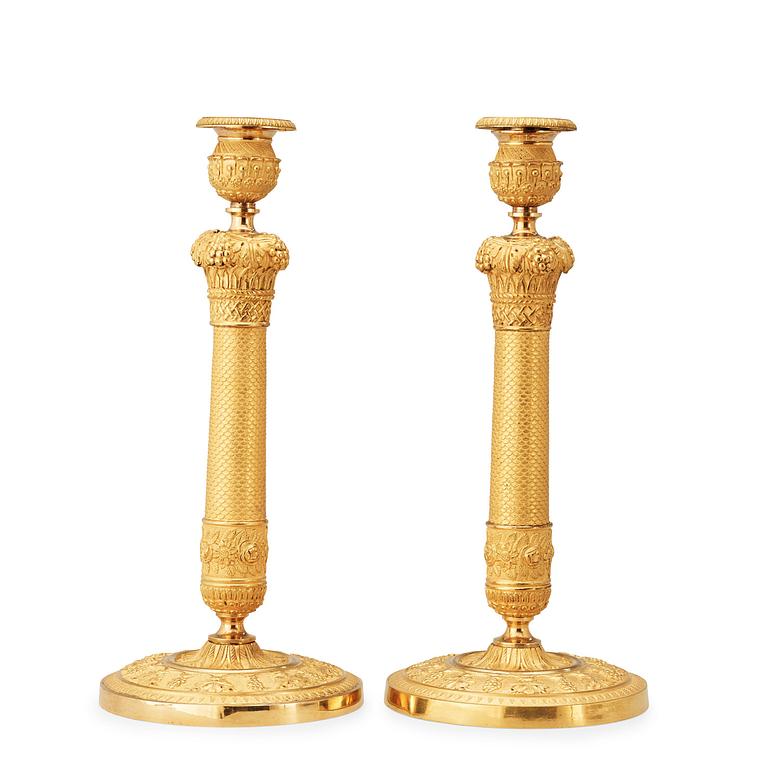A pair of French Empire early 19th cenury gilt bronze candlesticks.