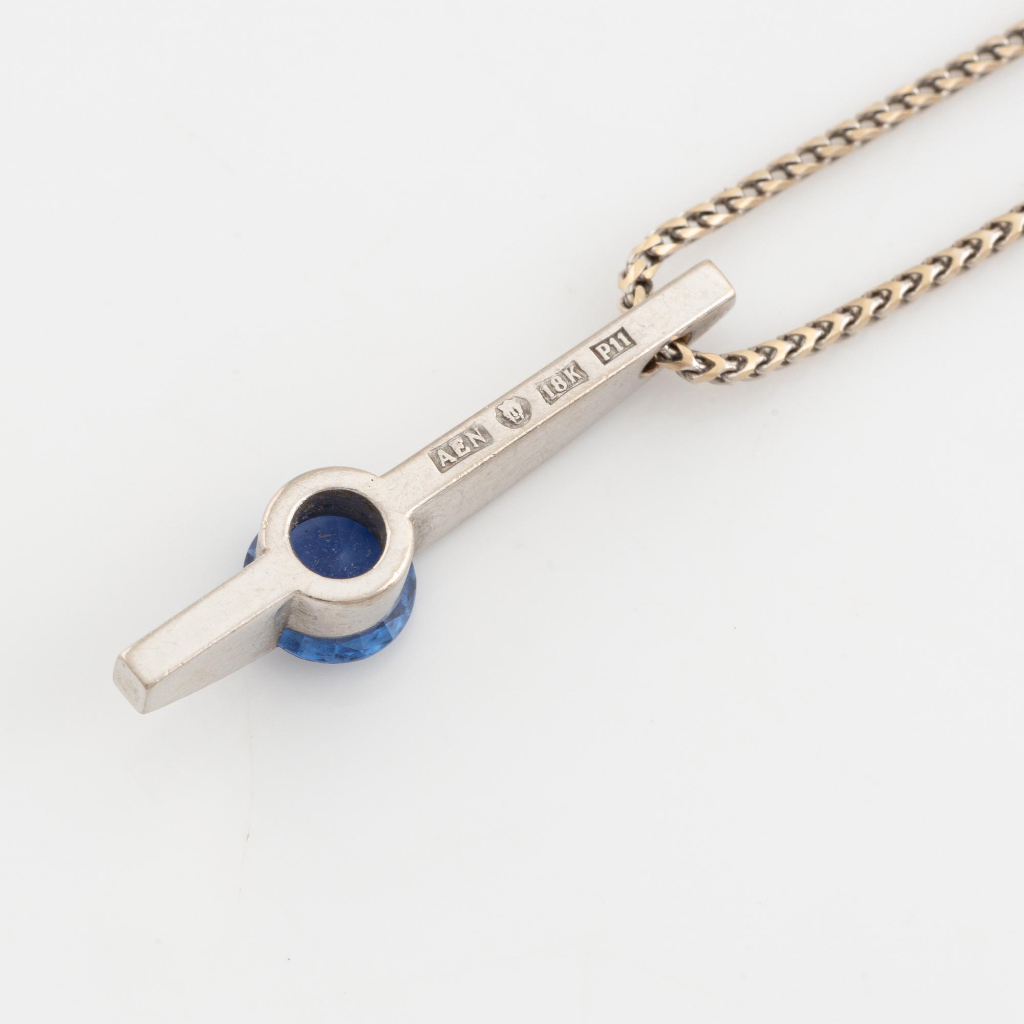 An 18K white gold necklace with a faceted sapphire and brilliant cut diamonds.
