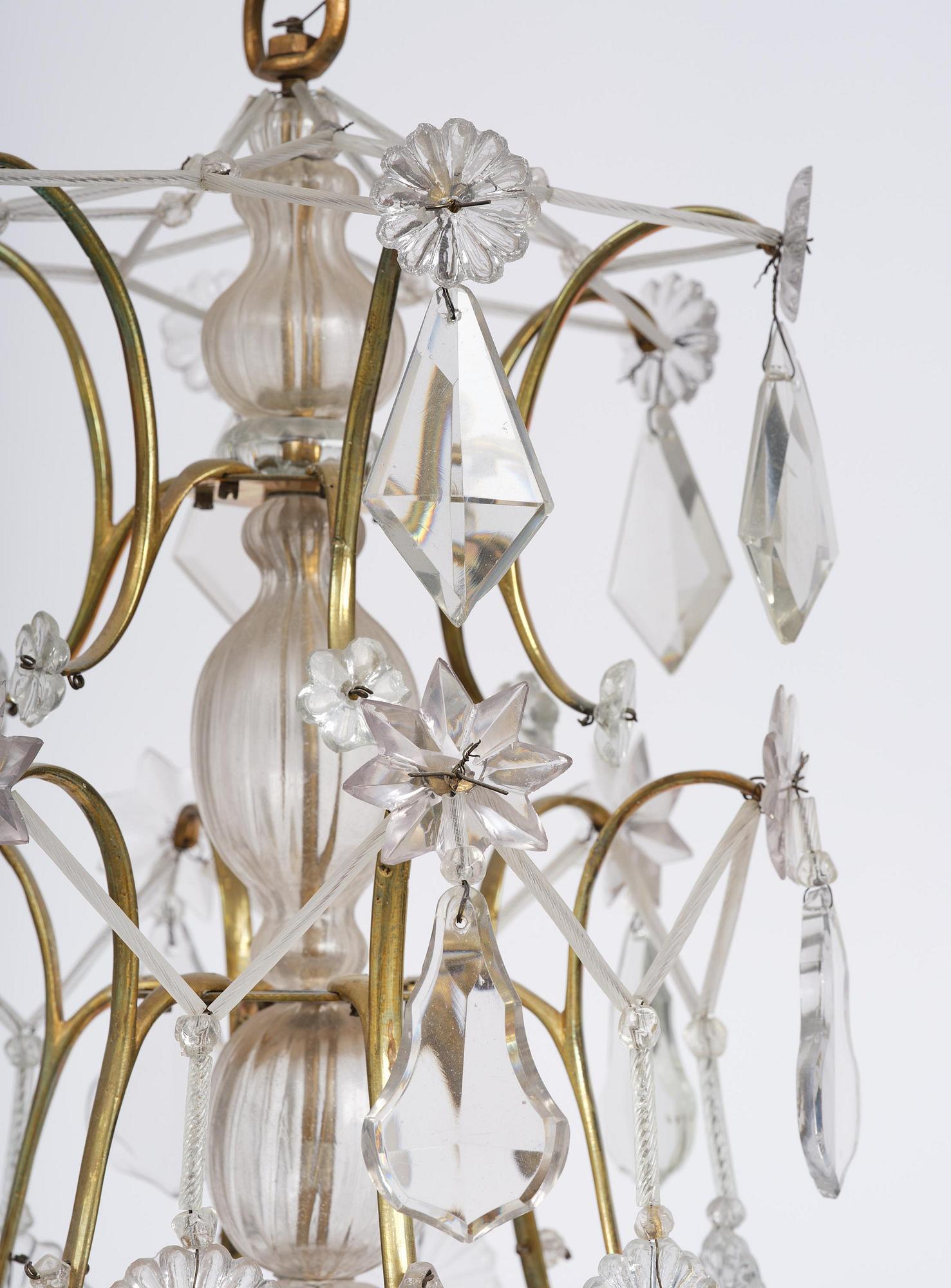 A near pair of rococo-style gilt brass and cut glass six-branch chandeliers, 19th century incorporating older elements.