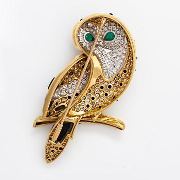 An owl brooch made of gold with diamodns ca. 4.00 ct in total, emeralds and onyx.