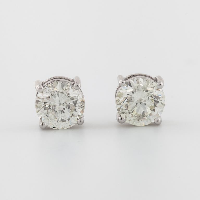 A pair of brilliant cut diamond earrings.