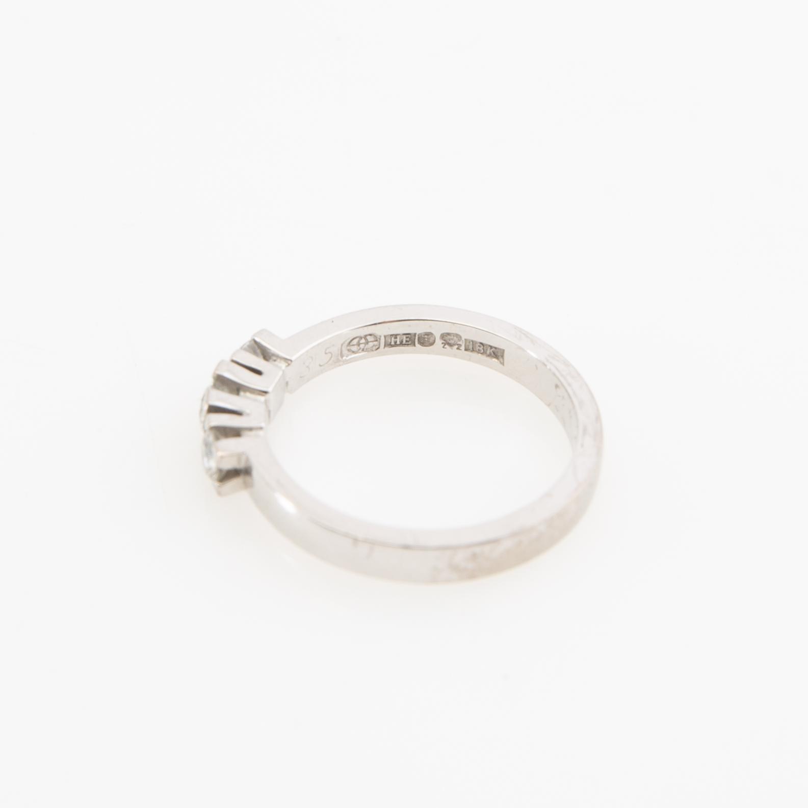 Ring, 18K vitguld med tre runda briljantslipade diamanter.