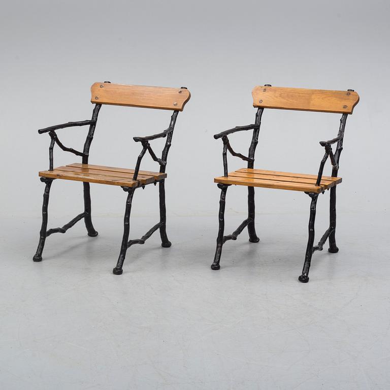 a pair of early 20th century garden cast iron chairs.