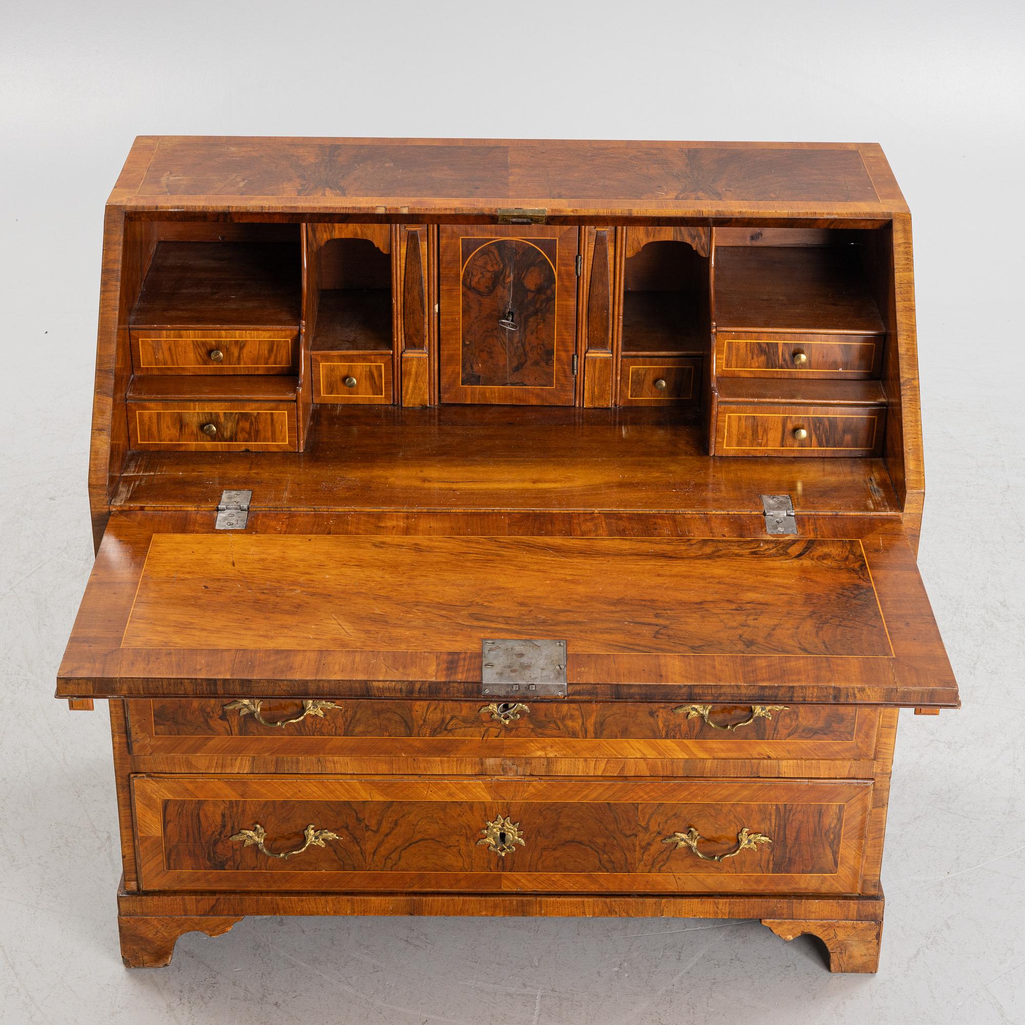 A rococo walnut-veneered and gilt-brass mounted secretaire, later part of the 18th century.