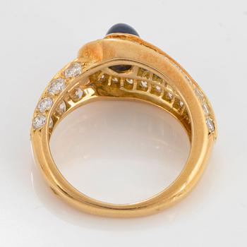 An 18K gold Wempe ring set with sapphires and round brilliant-cut diamonds.