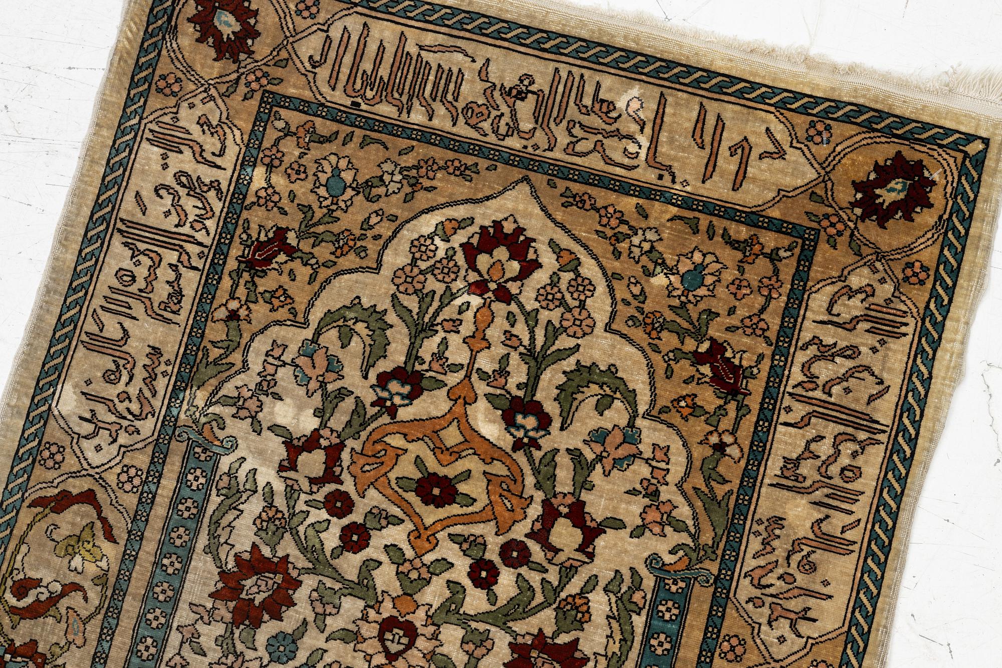 A Hereke silk rug, c. 73 x 52 cm.