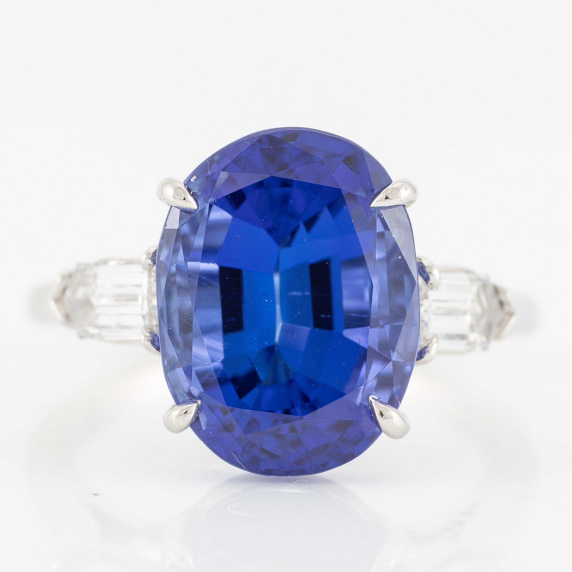 Ring, Fred Leighton platinum with an oval faceted tanzanite and fancy-cut diamonds.