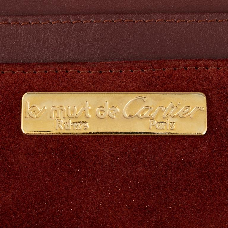 Cartier, a red suede clutch.