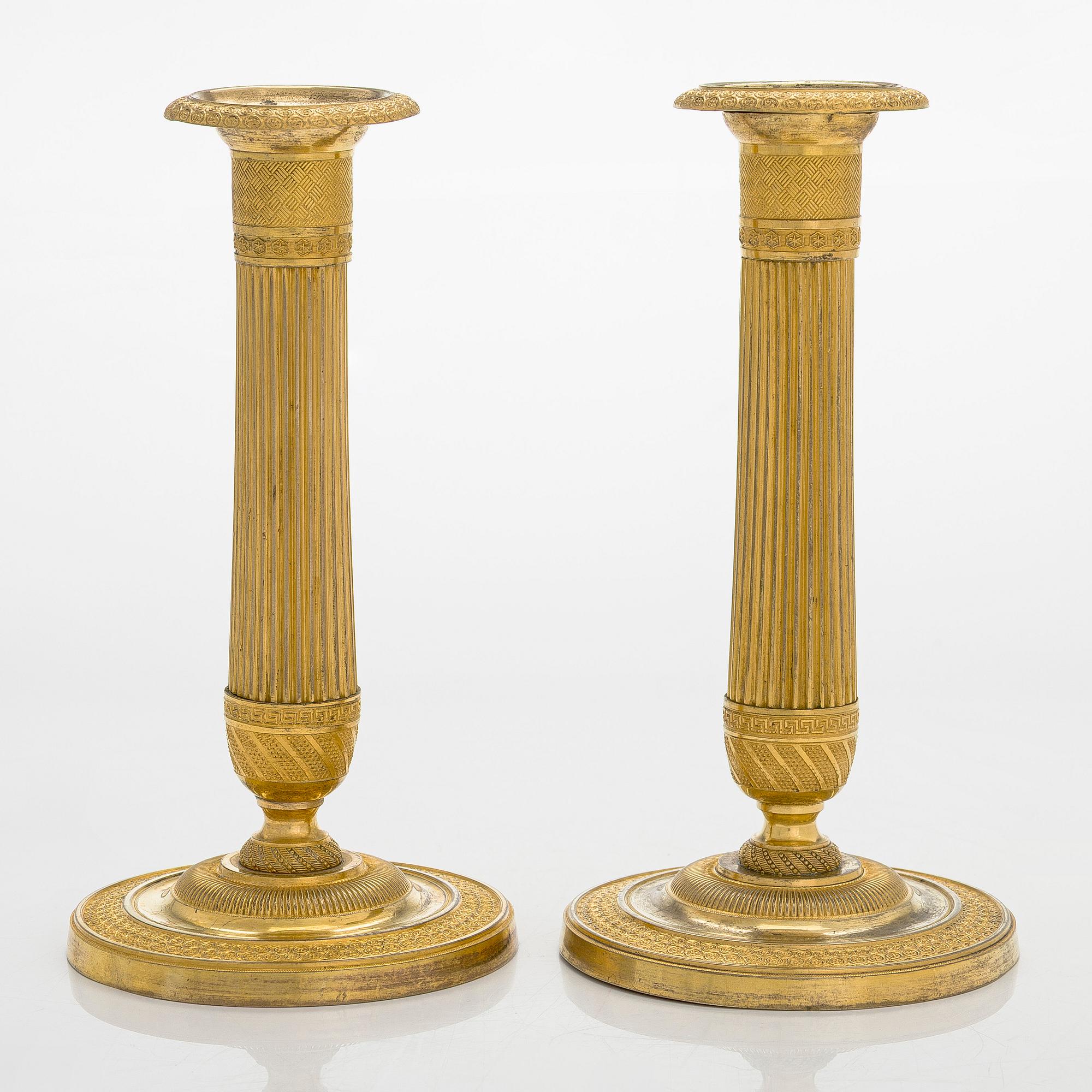 A pair of French gilded Empire candlesticks, early 19th century.