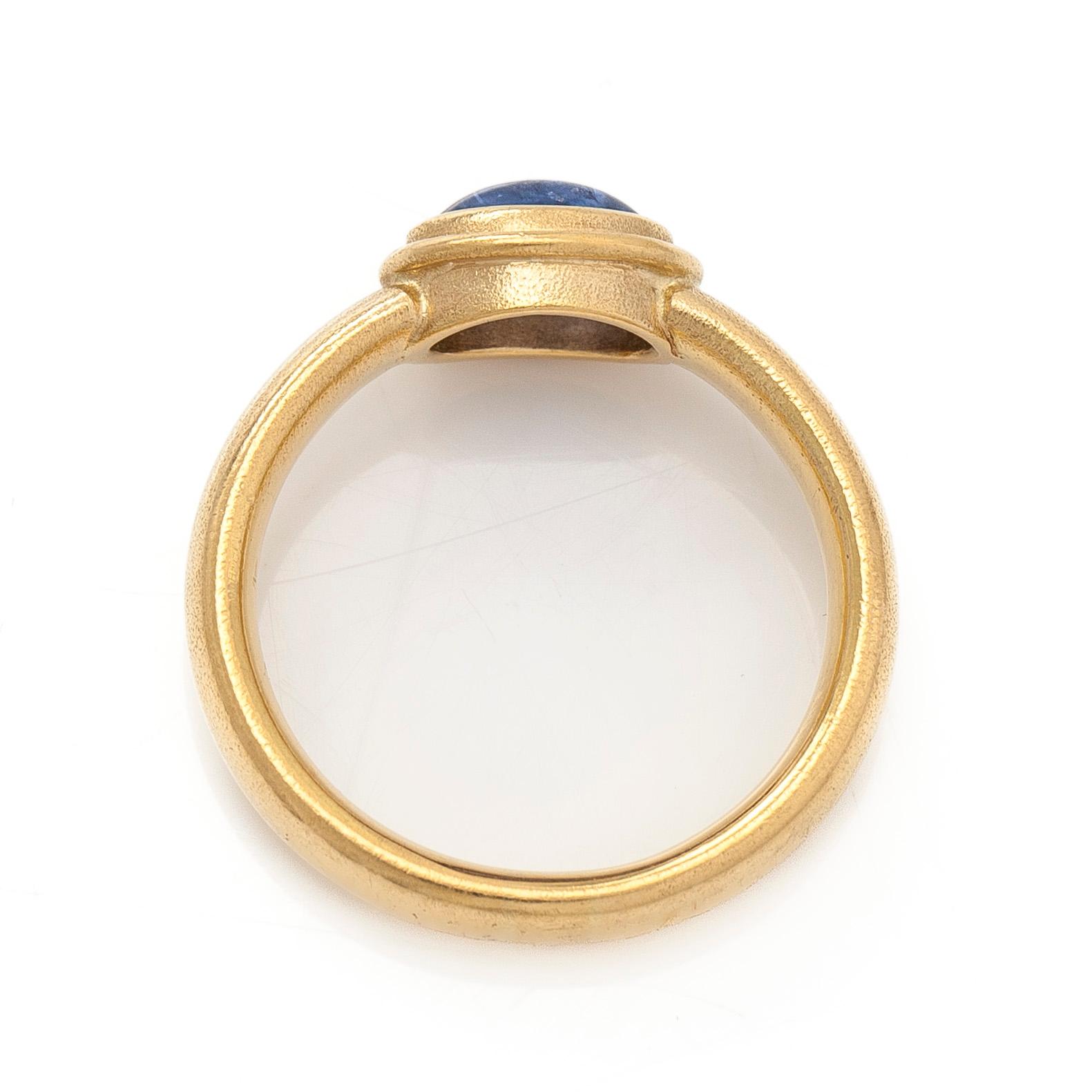 An 18K gold ring with a cabochon-cut sapphire.