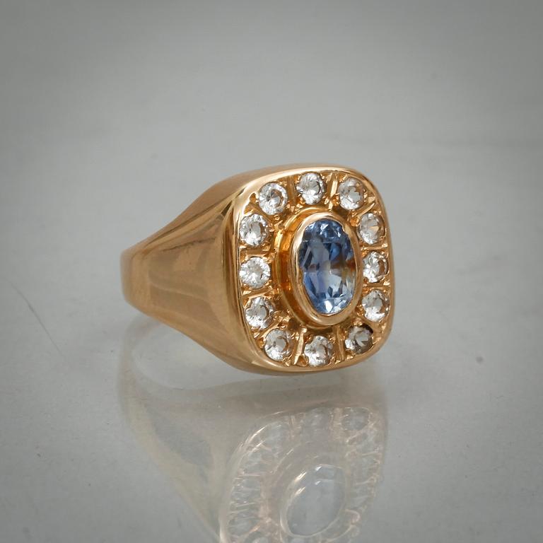 RING, 18k guld med fasettslipade vita safirer samt blå safir. Vikt 6,3 g.