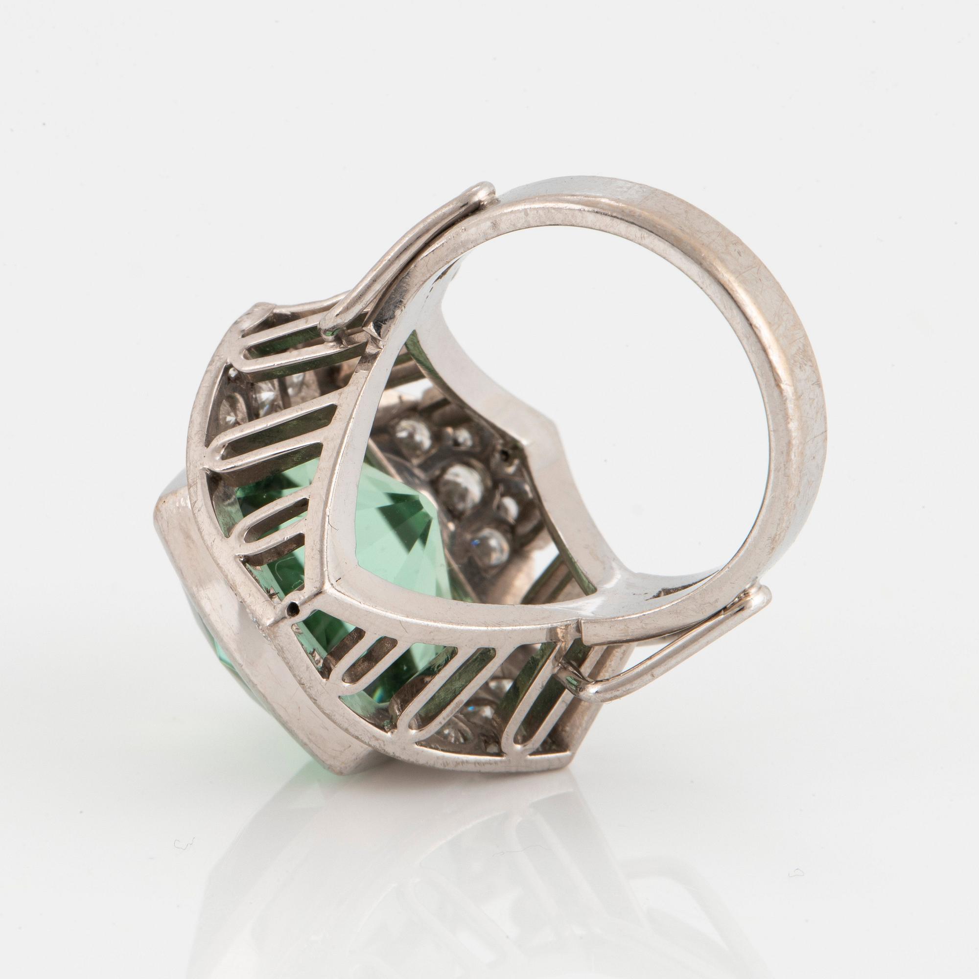 An 18K white gold ring set with a faceted tourmaline and round brilliant- and eight-cut diamonds.