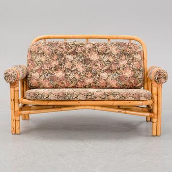 A set of two garden sofas, an armchair and a glass table, later part of the 20th Century.