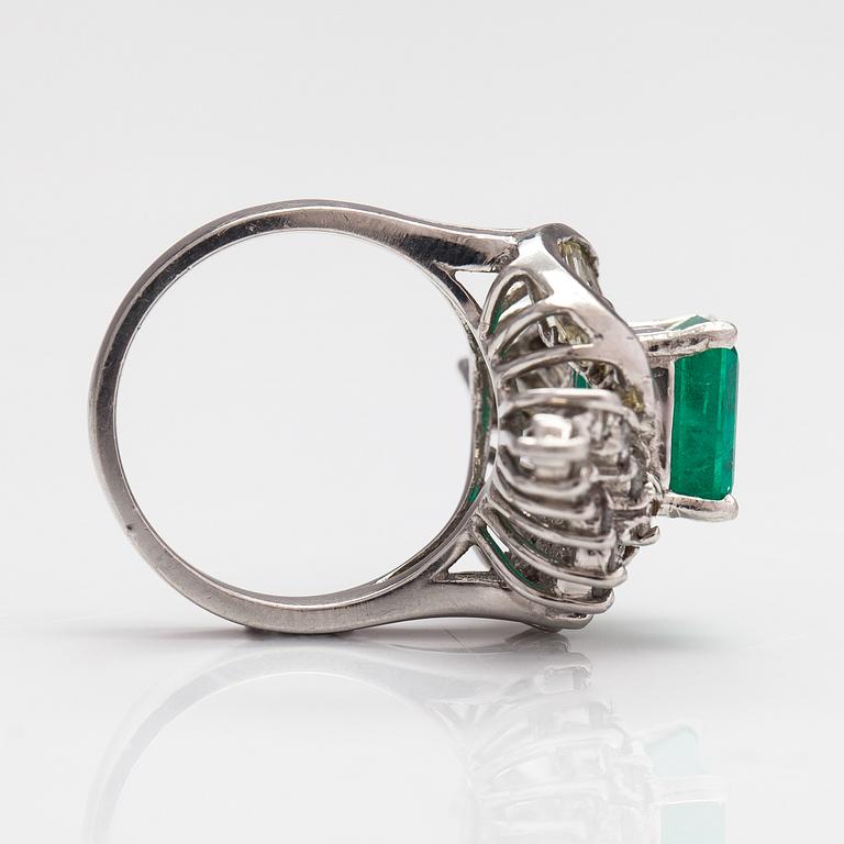 A platinum ring with a ca. 3.20 ct emerald and diamonds ca. 1.16 ct in total.
