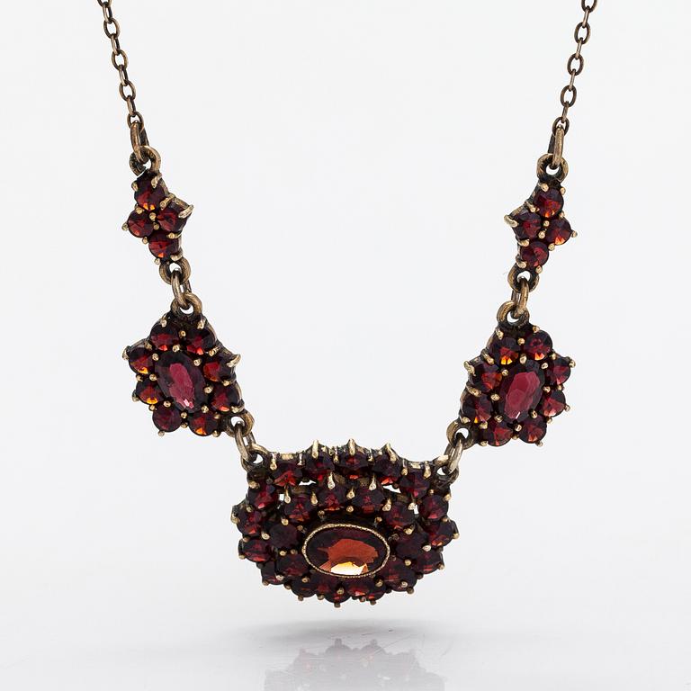 A necklace, brooch and earrings, gilded silver and garnets.