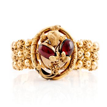 An 18K gold bracelet set with cabochon-cut garnets.