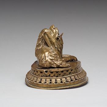 A copper alloy figure of a reclining buddhist lion, presumably 18th Century.